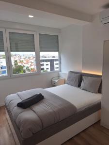 1 dormitorio con 1 cama grande y 2 ventanas en Lisbon South Bay Rooms 2, en Almada