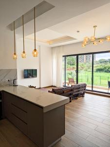una cucina e un soggiorno con una grande finestra di Riverbank One Bedrooms Apartment, Swimming pool, gym, workspace, DB Space Living a Nairobi