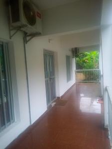 an empty room with white walls and a hallway with windows at Résidence la Lobe in Kribi