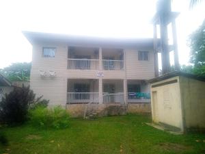 a large white building with windows and a yard at Résidence la Lobe in Kribi