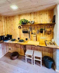 a kitchen with wooden walls and a counter with stools at Baltic Sea Cottage in Jūrmala +21 photos