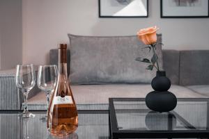 uma garrafa de vinho e um vaso com uma rosa sobre uma mesa em Athens City Chic Apartment-2 bathrooms em Atenas