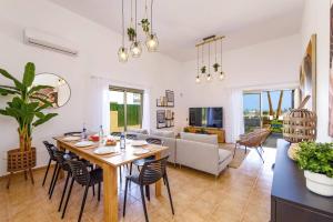 a dining room and living room with a table and chairs at Villa Humaik by Villa Plus in Antigua