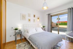 a white bedroom with a bed and a sliding glass door at Villa Humaik by Villa Plus in Antigua +13 photos