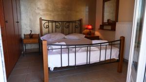 a bedroom with a bed with a wrought iron frame at Remenata in Lixouri