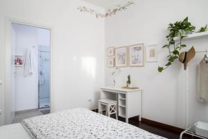 Habitación blanca con escritorio y cama en Casa di Anna, en Pesaro