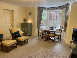 a living room with a table and chairs and a television at Ground floor garden apartment in Newark upon Trent
