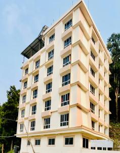 a large white building with windows at Staynest Regency Pelling in Pelling