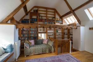a living room with a couch and book shelves at The Old Library in Castle Combe