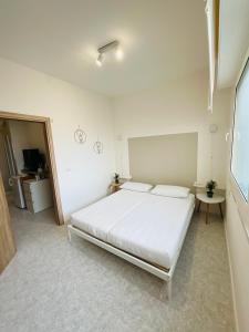 um quarto com uma cama branca num quarto em SeaSide BnB -Elegante Appartamento- FRONTE MARE em Porto San Giorgio