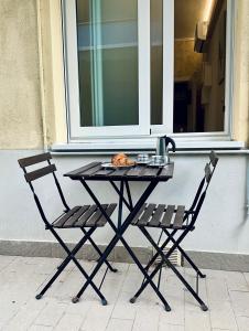 uma mesa e duas cadeiras sentadas ao lado de uma janela em SeaSide BnB -Elegante Appartamento- FRONTE MARE em Porto San Giorgio