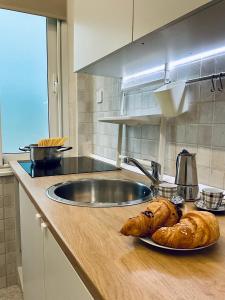 um balcão de cozinha com dois pães num prato em SeaSide BnB -Elegante Appartamento- FRONTE MARE em Porto San Giorgio
