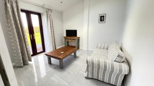 a living room with a couch and a table at The Old Mountain Stables Caerllwyn Ganol Farm in Newport