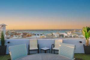 Un balcón con sillas y una mesa y vista al mar. en Billia's Casa, en Rethymno