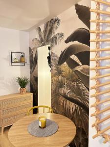- une table dans une pièce ornée d'une fresque murale de palmiers dans l'établissement Selva - Studio cosy et chaleureux, à Saran