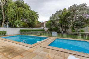 a swimming pool with a fence and trees at Casa Alfazema - Próx Barra Shopping, Pontal, Orla Guaíba in Porto Alegre