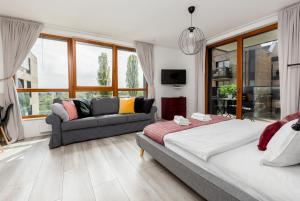 um quarto com uma cama e um sofá em Palm Aparts Gdańsk em Gdansk
