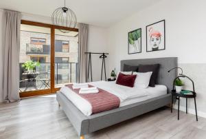 a bedroom with a large bed and a window at Palm Aparts Gdańsk in Gdańsk