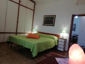 una camera con letto verde e specchio di Country Rooms ad Alghero