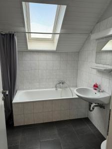 uma casa de banho com uma banheira, um lavatório e uma janela em Domum 5 Moderne Ferien- Monteurapartments inkl Wlan und Waschmaschine in Mülheim an der Ruhr em Mülheim an der Ruhr