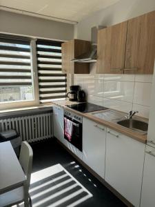 uma cozinha com armários brancos e um forno com placa de fogão em Domum 5 Moderne Ferien- Monteurapartments inkl Wlan und Waschmaschine in Mülheim an der Ruhr em Mülheim an der Ruhr