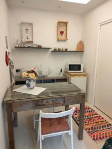 a kitchen with a wooden table with a vase of flowers at La petite suite in Calenzano