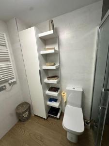 a bathroom with a white toilet in a room at Cala Currican by Bossh! Apartments in Chipiona