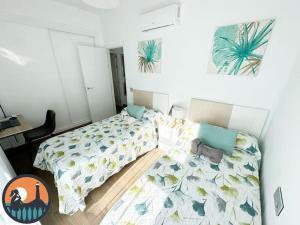 a small bedroom with two beds and a desk at Cala Currican by Bossh! Apartments in Chipiona +12 photos
