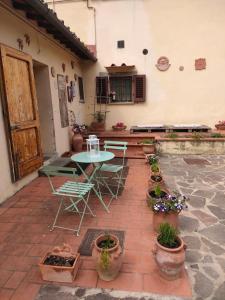 a patio with a table and chairs and potted plants at La petite suite in Calenzano