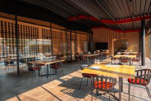 un ristorante con tavoli e sedie in legno e finestre di Agriturismo Baglio Donnafranca Wine Resort a Marsala