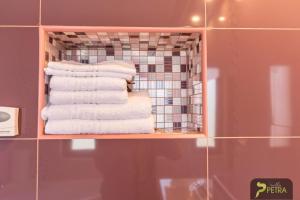 un mucchio di asciugamani su una mensola in bagno di Vila Petra a Cristian