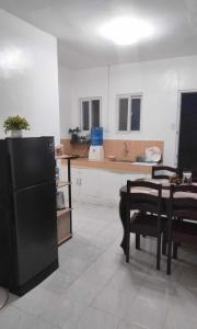 eine Küche mit einem schwarzen Kühlschrank und einem Tisch in der Unterkunft DAVAO Transient House 2 in Davao City