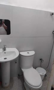 ein weißes Bad mit einem WC und einem Waschbecken in der Unterkunft DAVAO Transient House 2 in Davao City