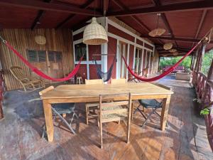 einen Holztisch auf einer Veranda mit Stühlen und einer Hängematte in der Unterkunft 300m to beach/center: 2 bedr-2 bath & great views! in San Juan del Sur