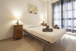 a bedroom with a bed with two towels on it at Apartamento Terraza Bora Bora in El Campello