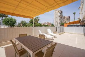 a patio with a table and chairs on a roof at Apartamento Terraza Bora Bora in El Campello