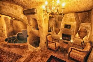 a living room with a fireplace and a chandelier at The Dorm Cave By Travellers in Goreme