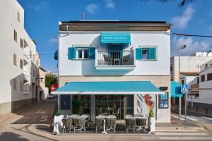 a store with tables and chairs in front of a building at Hotel Colonial in Colonia Sant Jordi