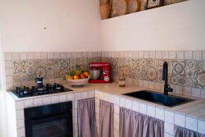 a kitchen with a sink and a counter top at Borgo Maria Rosa - Relax tra Nebrodi e Mare in San Salvatore di Fitalia