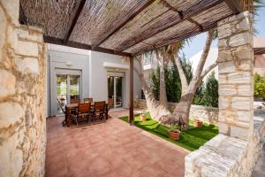 an outdoor patio with a table and chairs at Urania Luxury Suite with pool view -Loutra Resort in Loutra