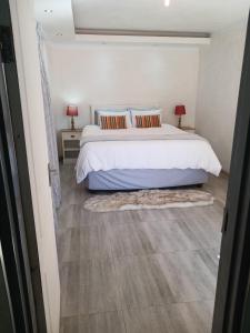 1 dormitorio con 1 cama, 2 mesitas de noche y 2 lámparas en Russell's Rest Rooms en Johannesburgo