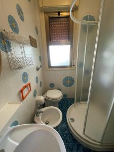 y baño con ducha, aseo y lavamanos. en Appartamenti Residence Foscolo, en Lido di Jesolo