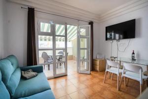 a living room with a blue couch and a table with chairs at Orlando 85 Complex - Costa Adeje in Adeje