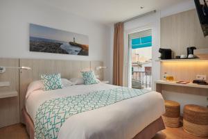 a hotel room with a large bed and a window at Hotel Colonial in Colònia de Sant Jordi