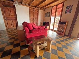 a living room with a red couch and a glass table at 300m to beach/center: 2 bedr-2 bath & great views! in San Juan del Sur