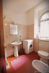y baño con aseo blanco y lavamanos. en Lunigiana Experience en Pontremoli
