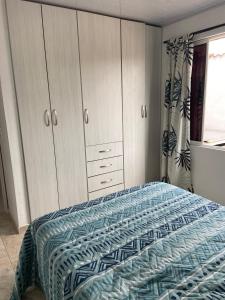 a bedroom with a bed and cabinets and a window at Apartamento Fontana 3 in Bucaramanga