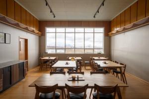 a restaurant with tables and chairs and a large window at Skulagardur Country Hotel in Garður