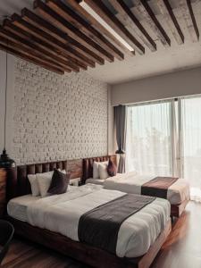 a bedroom with two beds and a large window at Jade City Hotel in Pokhara