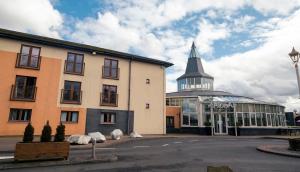 a building with a steeple and a building with a church at Alona Hotel in Motherwell